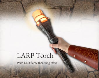 Könnte beinhalten: Eine LARP-Fackel mit einem dunkelmetallischen Griff und einem leuchtenden orangefarbenen LED-Flammeneffekt an der Spitze, befestigt mit Bindfaden. Der Text LARP Torch With LED flame flickering effect ist links im Bild zu sehen.
