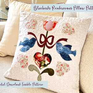Può includere: Un cuscino bianco con un design di uccelli azzurri, fiori e cuori. Il cuscino è realizzato con un modello fusibile ed è un download digitale. Il testo "Bluebirds Rendezvous Pillow Pattern" è nella parte superiore del cuscino e il testo "Digital Download Fusible Pattern" è nella parte inferiore del cuscino.