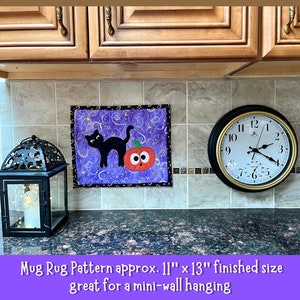 Puede incluir: Un tapete para taza morado y negro con un gato negro y un dise&ntilde;o de calabaza. El tapete para taza mide aproximadamente 11 pulgadas por 13 pulgadas. "Mug Rug Pattern approx. 11" x 13" finished size great for a mini-wall hanging"