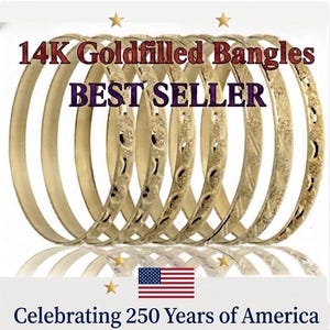 May include: A set of 14K gold-filled bangles with various textured patterns. The image features the text 14K Goldfilled Bangles, BEST SELLER, and Celebrating 250 Years of America, along with a graphic of the American flag and gold stars.