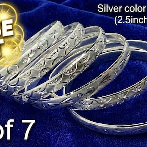 May include: A set of seven silver-colored bangles with intricate etched designs. The bangles have a 2.5-inch diameter and are displayed on a blue velvet surface. Text on the image reads "CLOSE OUT" and "set of 7".