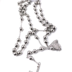 Peut inclure: Un collier de chapelet en argent avec un pendentif en croix en argent et un charme en médaille en argent. Les perles du chapelet sont rondes et ont une finition lisse.