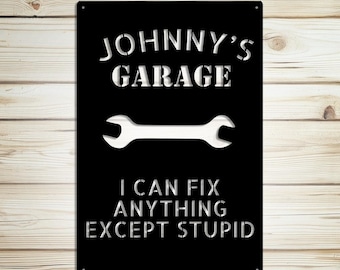 May include: Black metal garage sign with the text "JOHNNY'S GARAGE" and "I CAN FIX ANYTHING EXCEPT STUPID" in white. A white wrench graphic is centered below the word "GARAGE".