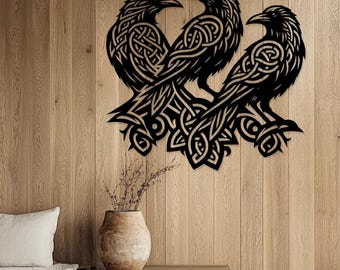 May include: A black metal wall art piece featuring three ravens with intricate Celtic knotwork designs. The ravens are perched together, creating a symmetrical and decorative display. The artwork is mounted on a wooden wall, adding a rustic touch.