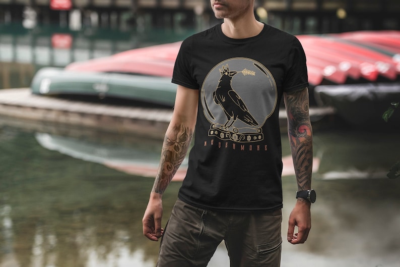 May include: Black t-shirt with a graphic of a crow wearing a crown inside a glass orb. The text "NEVERMORE" is printed below the orb.