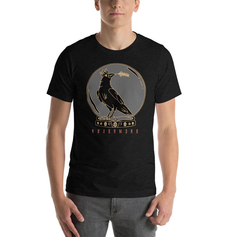 May include: A black t-shirt with a graphic of a crow wearing a crown inside a glass sphere. The text "Nevermore" is printed below the sphere.