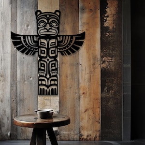 May include: Black metal wall art depicting a stylized Native American totem pole with a bird design. The totem pole is mounted on a wood panel background.