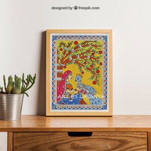 May include: A framed painting of a woman in a red and blue dress sitting under a tree with a peacock. The painting is in a traditional Indian style with bright colors and intricate details. The text "ART BY LAVANYA" is at the bottom of the painting.