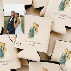 May include: Beige wedding can coolers with a watercolor illustration of a couple and the text "THE THOMPSONS 12.06.2025". The coolers have a black trim and are designed to keep beverages cold.