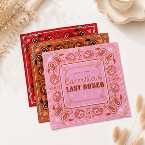 Könnte beinhalten: Drei quadratische Bandanas in Rot, Orange und Rosa, jeweils mit einem Paisley-Muster. Das rosa Bandana zeigt den Text "Camila's Last Rodeo" in einer dekorativen Schriftart, mit zusätzlichem Text darüber. Die Bandanas sind gefaltet und geschichtet.