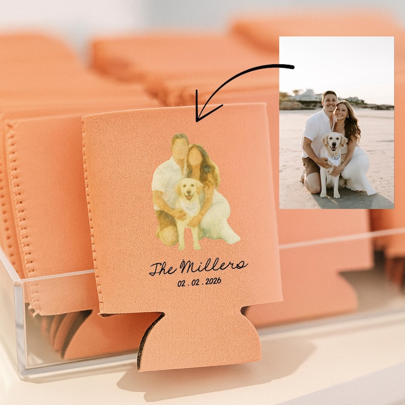 May include: Peach-colored can coolers with a custom photo of a couple and their dog. The text "The Millers" and the date "02.02.2026" are printed below the image. The coolers are displayed in a clear acrylic container.