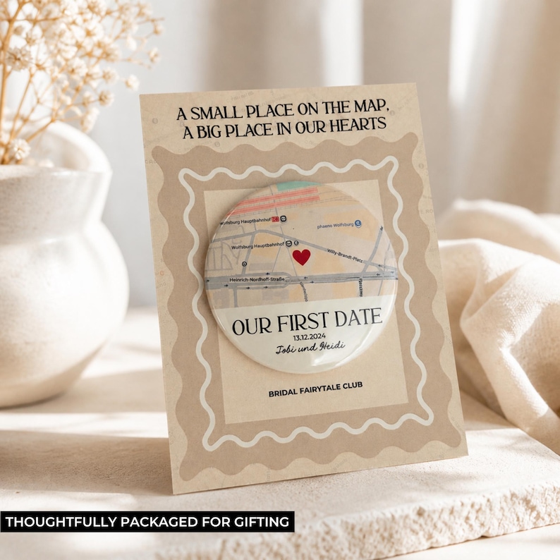 May include: A personalized gift card with a map design. The card features the text "A SMALL PLACE ON THE MAP, A BIG PLACE IN OUR HEARTS" and "OUR FIRST DATE" with a date and names. The card is packaged for gifting.