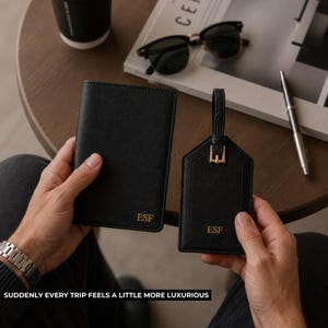 Peut inclure: Un porte-passeport et une &eacute;tiquette de bagage noirs avec les initiales dor&eacute;es "ESF". L'&eacute;tiquette de bagage a une boucle dor&eacute;e. Le texte en bas dit "SUDDENLY EVERY TRIP FEELS A LITTLE MORE LUXURIOUS".