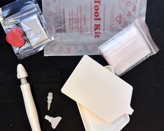 May include: A diamond painting tool kit with a white applicator pen, trays, and bags of supplies. The kit includes a tray with a lid, putty, and multi placers. The text "Tool Kit" is printed on the packaging.