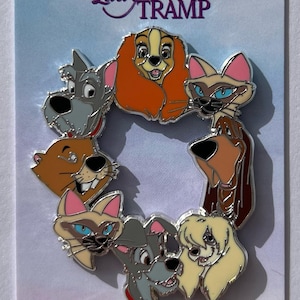 Puede incluir: Un pin circular de esmalte con personajes de "La Dama y el Vagabundo" de Disney. El pin muestra a los perros y gatos en un diseño colorido. El pin tiene un borde plateado y las palabras "Lady and the Tramp" en la parte superior.