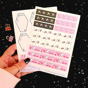 May include: A hand holds several sheets of stickers with a spooky theme. The stickers feature coffin shapes with "Kill List" text, and repeating patterns of knives, cleavers, and blood splatters in pink, white, and black. The Haunted Halo Etsy shop is visible.