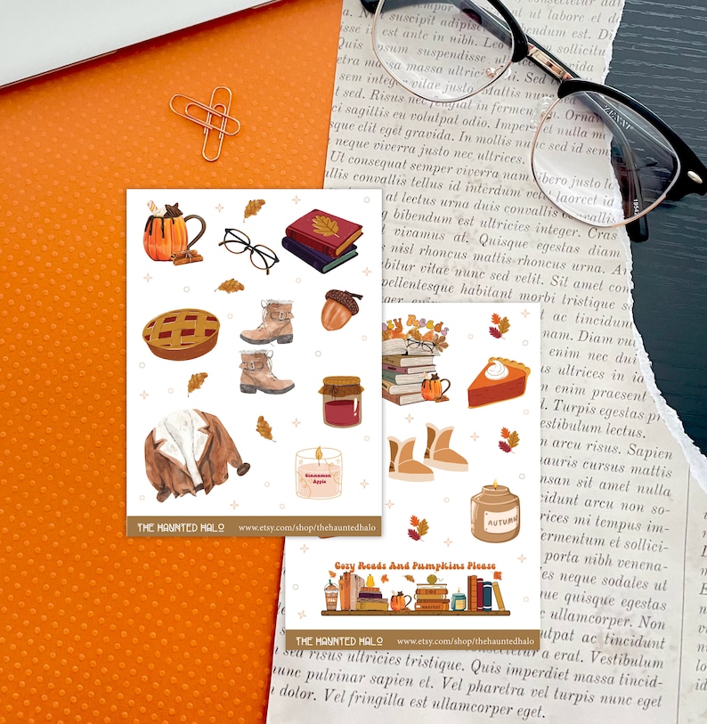 May include: A set of 12 autumn-themed stickers featuring illustrations of books, glasses, a mug of hot cocoa, a pie, a jacket, a candle, a jar of jam, boots, and acorns. The stickers are on a white background with the text "Cozy Reads And Pumpkins Please" and "The Haunted Halo" on the bottom.