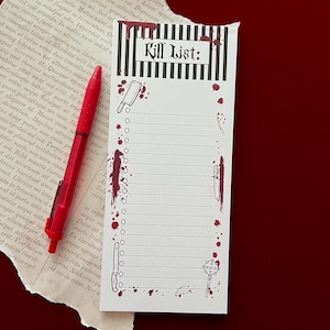 May include: A rectangular notepad with a white background and black vertical stripes at the top, featuring the text "Kill List:" in a gothic font. The notepad includes red blood splatter graphics, illustrations of a cleaver, knife, and mace, and a red pen.