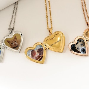 May include: Three silver, gold, and rose gold heart-shaped locket necklaces with different photos inside. The gold locket has the inscription "Love You Noah".