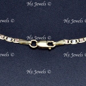 May include: A close-up of a gold chain necklace with a lobster clasp. The chain is made of three different colors of gold: yellow, white, and rose.