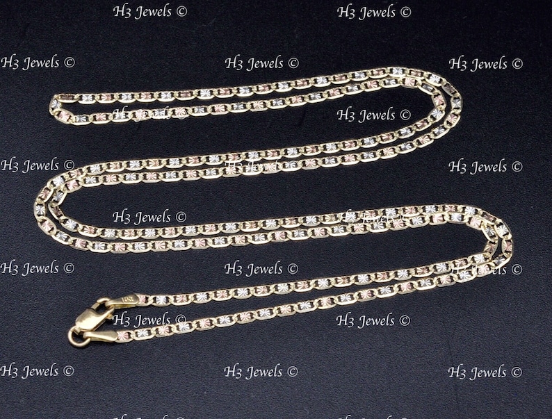 May include: Two gold chains, one longer than the other, with a tri-color design of yellow, white, and rose gold. The chains are made of a box link style. The chains are on a black background.