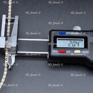 May include: A close-up of a gold chain being measured with a digital caliper. The caliper reads 2.04 mm.
