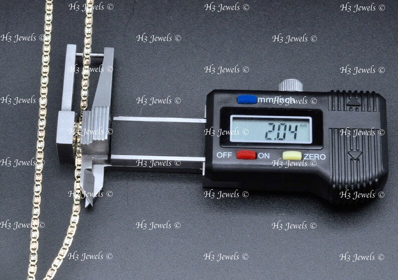 May include: A close-up of a gold chain being measured with a digital caliper. The caliper reads 2.04 mm.