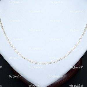 May include: A gold chain necklace with a delicate, rope-like design. The chain is displayed on a white display stand.