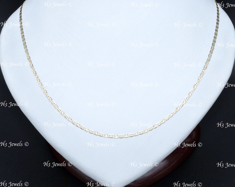 May include: A gold chain necklace with a delicate, rope-like design. The chain is displayed on a white display stand.