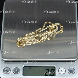 May include: A gold chain necklace on a digital scale. The scale reads 2.00 grams.
