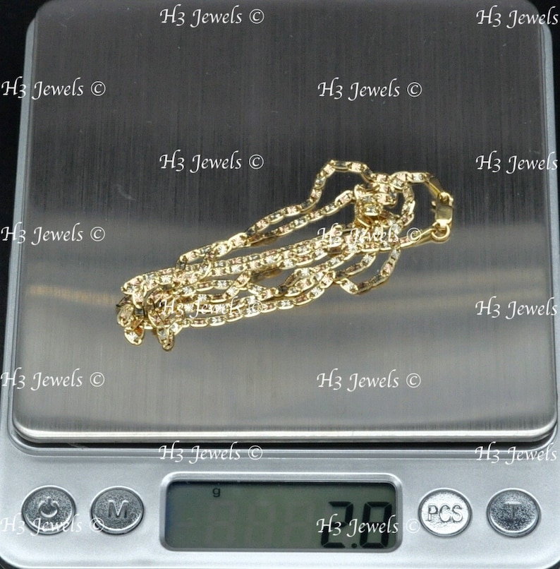 May include: A gold chain necklace on a digital scale. The scale reads 2.00 grams.