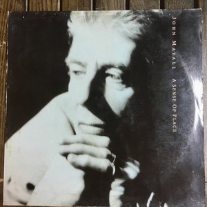 May include: A black and white photo of John Mayall on the cover of his album "A Sense of Place".