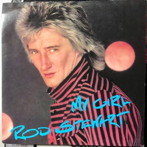 May include: Album cover featuring Rod Stewart in a black and red striped shirt. The turquoise text reads "My Girl" and "Rod Stewart". The background is dark with two pink circles.