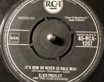 Può includere: Disco in vinile bianco e nero con un'etichetta che recita "It's Now or Never (O Sole Mio)" di Elvis Presley con The Jordanaires. Il numero del disco è 45-RCA-1207.