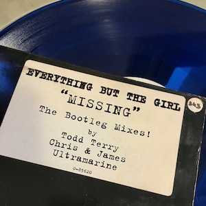 May include: A black and white record label with the text "EVERYTHING BUT THE GIRL" and "MISSING" in large white letters. The text "The Bootleg Mixes!" is below, followed by "by Todd Terry Chris & James Ultramarine" and "0-85620". A small white circle with the number "343" is in the upper right corner.