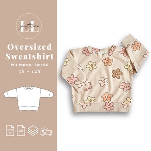 May include: A PDF pattern and tutorial for an oversized sweatshirt for children ages 5 to 12. The pattern includes a floral print with pink, yellow, and orange flowers on a beige background. The pattern is available in letter and A0 sizes.