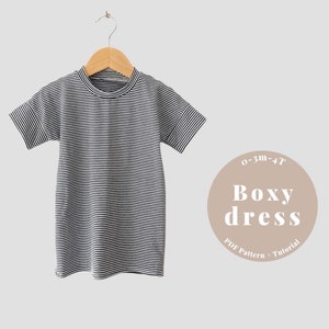 May include: A black and white striped boxy dress for babies and toddlers, sizes 0-3 months to 4T. The dress is hanging on a wooden hanger. The text "0-3m-4T Boxy dress PDF Pattern + Tutorial" is on a brown circle.