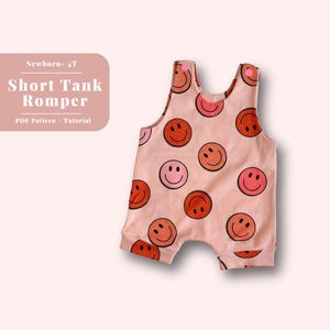 May include: A pink baby romper with a short tank top style and a pattern of colorful smiley faces. The romper is made of soft, comfortable fabric and is perfect for a baby's first summer.