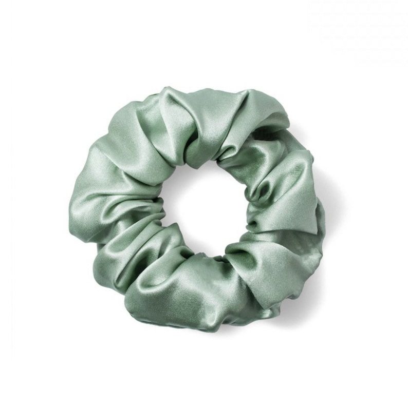 Pu&ograve; includere: Un elastico per capelli in raso verde salvia.