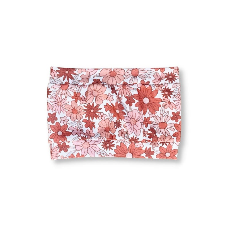 May include: A white fabric headband with a pink and red floral pattern.