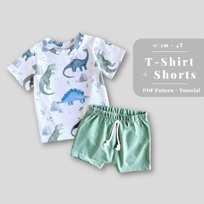 May include: A white t-shirt with a dinosaur print and green shorts. The t-shirt and shorts are laid out on a white background. The text "0/3m - 4T T-Shirt + Shorts PDF Pattern + Tutorial" is displayed above the clothing.