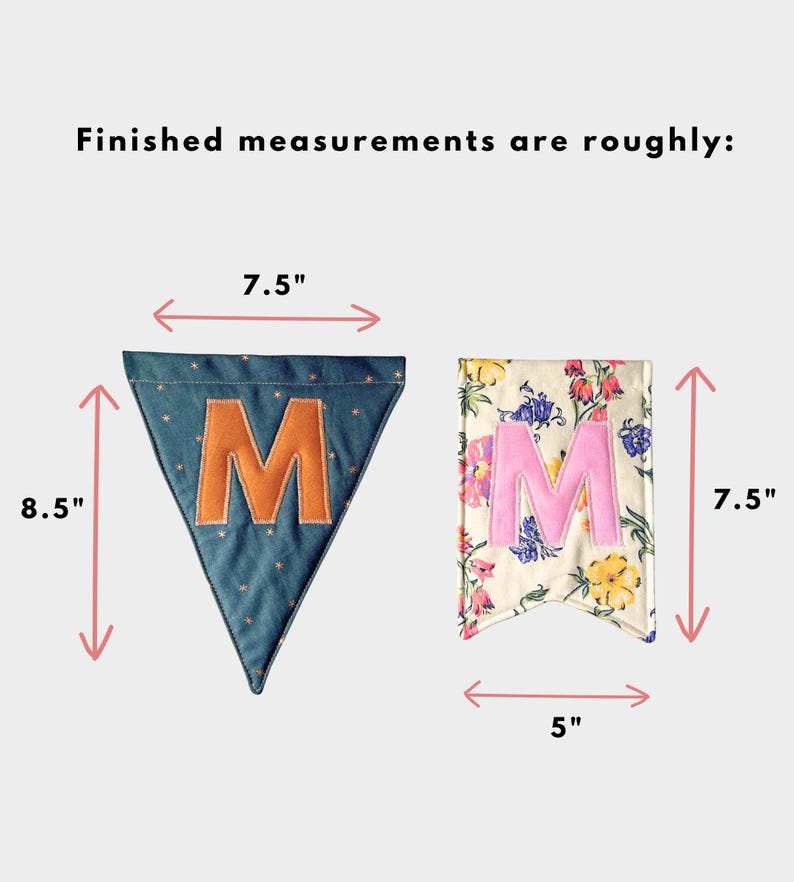 May include: Two fabric pennants with the text 'Finished measurements are roughly:'. The blue triangular pennant with a gold star pattern and orange letter 'M' measures 7.5 inches wide by 8.5 inches high. The floral rectangular pennant with a pink letter 'M' measures 5 inches wide by 7.5 inches high.