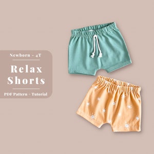 Puede incluir: Dos pares de pantalones cortos para beb&eacute;. Un par es de color verde azulado s&oacute;lido con un cord&oacute;n blanco. El otro par es de color naranja claro con un patr&oacute;n de sol blanco. El texto "Newborn - 4T Relax Shorts PDF Pattern + Tutorial" est&aacute; sobre un fondo rosa.