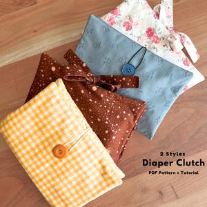 Peut inclure: Trois pochettes à couches en tissu avec différents motifs : un vichy jaune, un tissu marron avec des étoiles blanches, un tissu bleu avec des champignons, et une pochette à fleurs blanches. Le texte indique 2 Styles Diaper Clutch PDF Pattern + Tutorial.