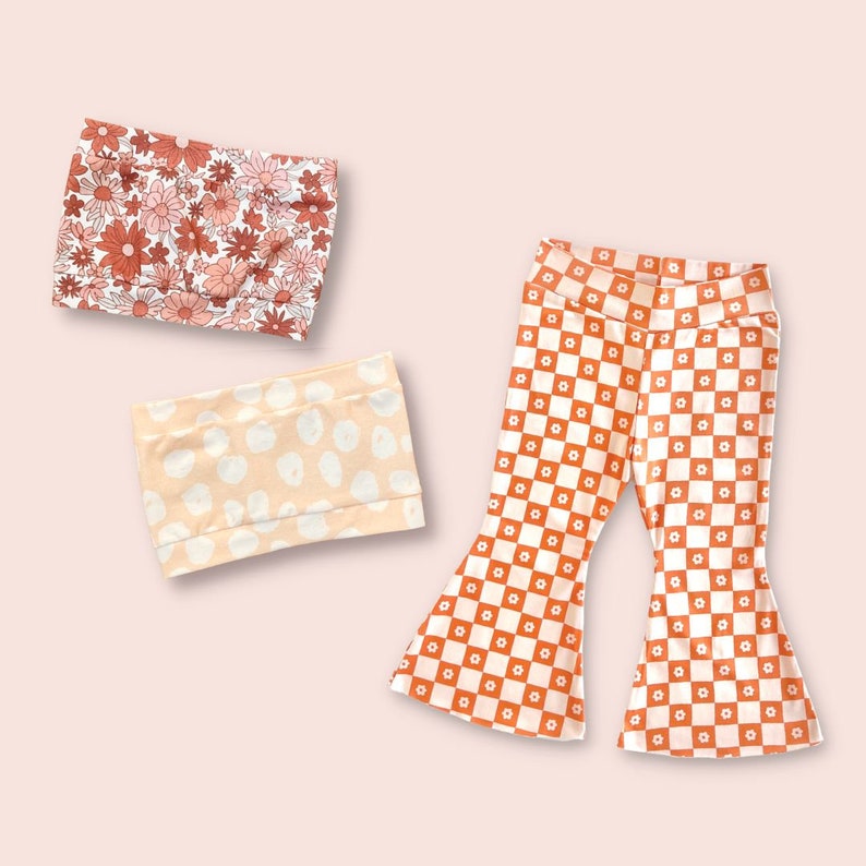 May include: Two orange and white patterned tube tops and a pair of orange and white checkered bell bottom pants.