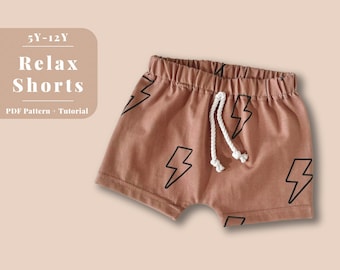 May include: A brown pair of shorts with a white drawstring and a black lightning bolt pattern. The shorts are labeled "Relax Shorts" and "5Y-12Y" with the text "PDF Pattern + Tutorial".
