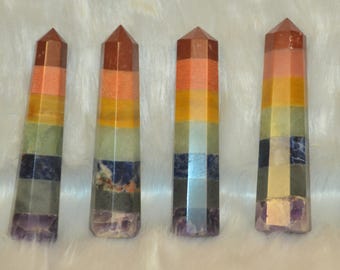 May include: Four seven chakra crystal wands, each with seven layers of different colored stones, including red, orange, yellow, green, blue, indigo, and violet.
