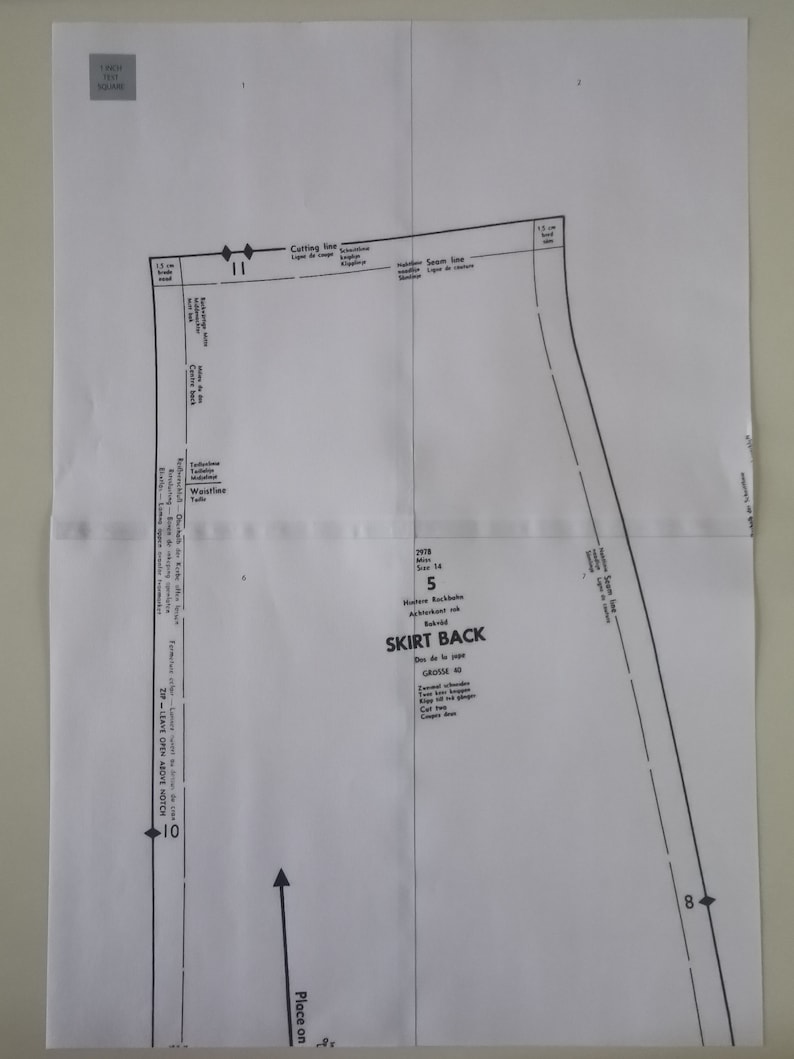 Op de afbeelding: Een zwart-wit naaipatroon voor de achterkant van een rok. Het patroon bevat instructies voor het knippen, naaien en plaatsen van de stof. Het patroon is voor maat 5 en is gemarkeerd met "SKIRT BACK".