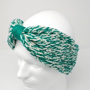 Puede incluir: Una diadema de punto verde y blanco con un diseño anudado. La diadema está hecha de un hilo suave y elástico y es perfecta para añadir un toque de estilo a cualquier atuendo.