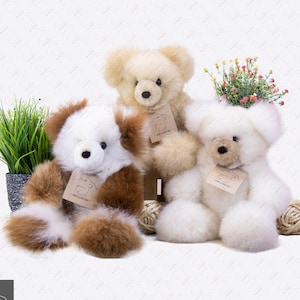 Może przedstawiać: Trzy pluszowe misie z alpaki, jeden biały, jeden brązowo-biały i jeden beżowy, siedzące na białym tle. Każdy miś ma małą metkę z napisem "Peru Alpaca".